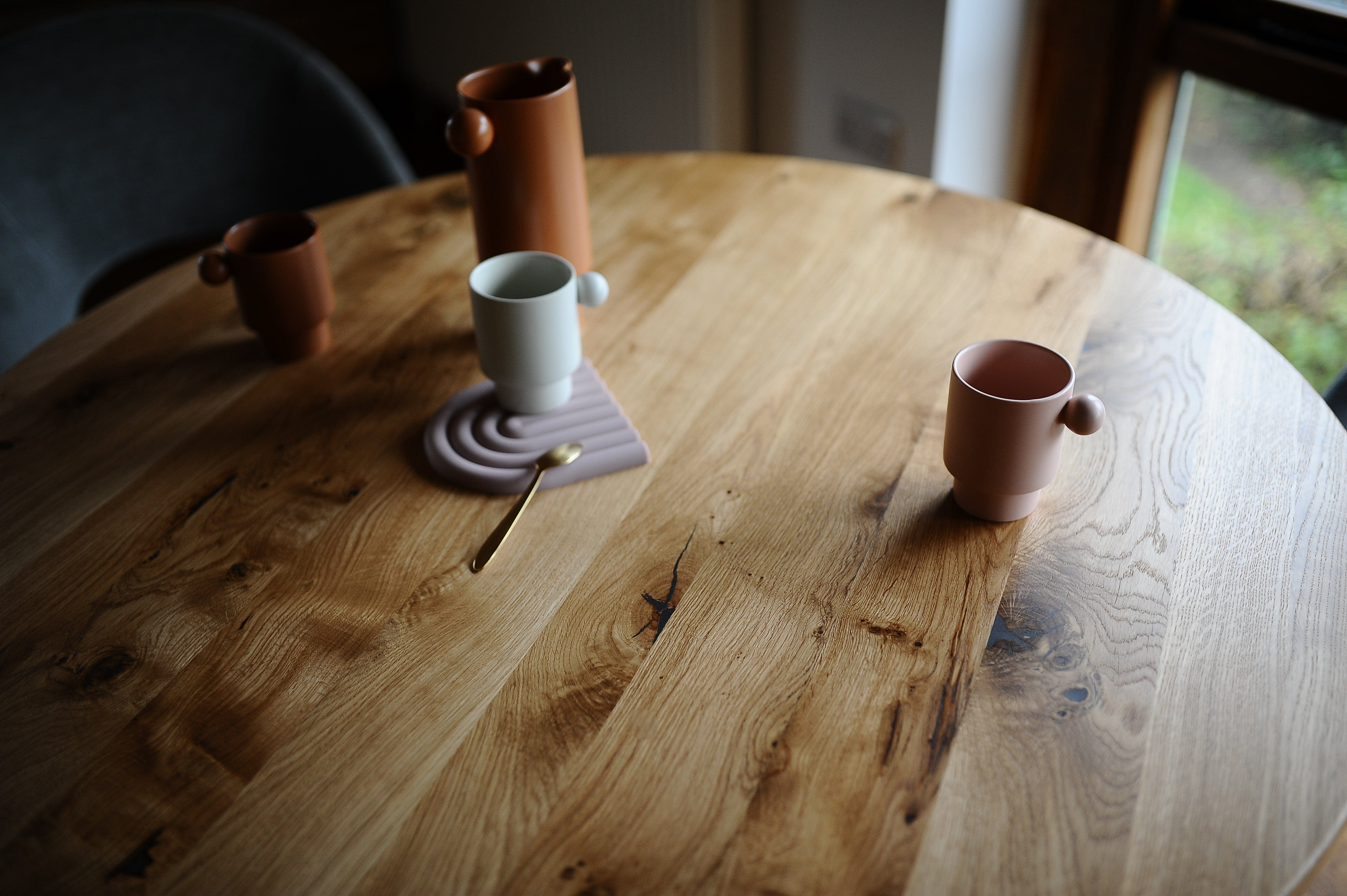 Oakwell solid character oak round dining table in modern dining room, with tea cups and jug