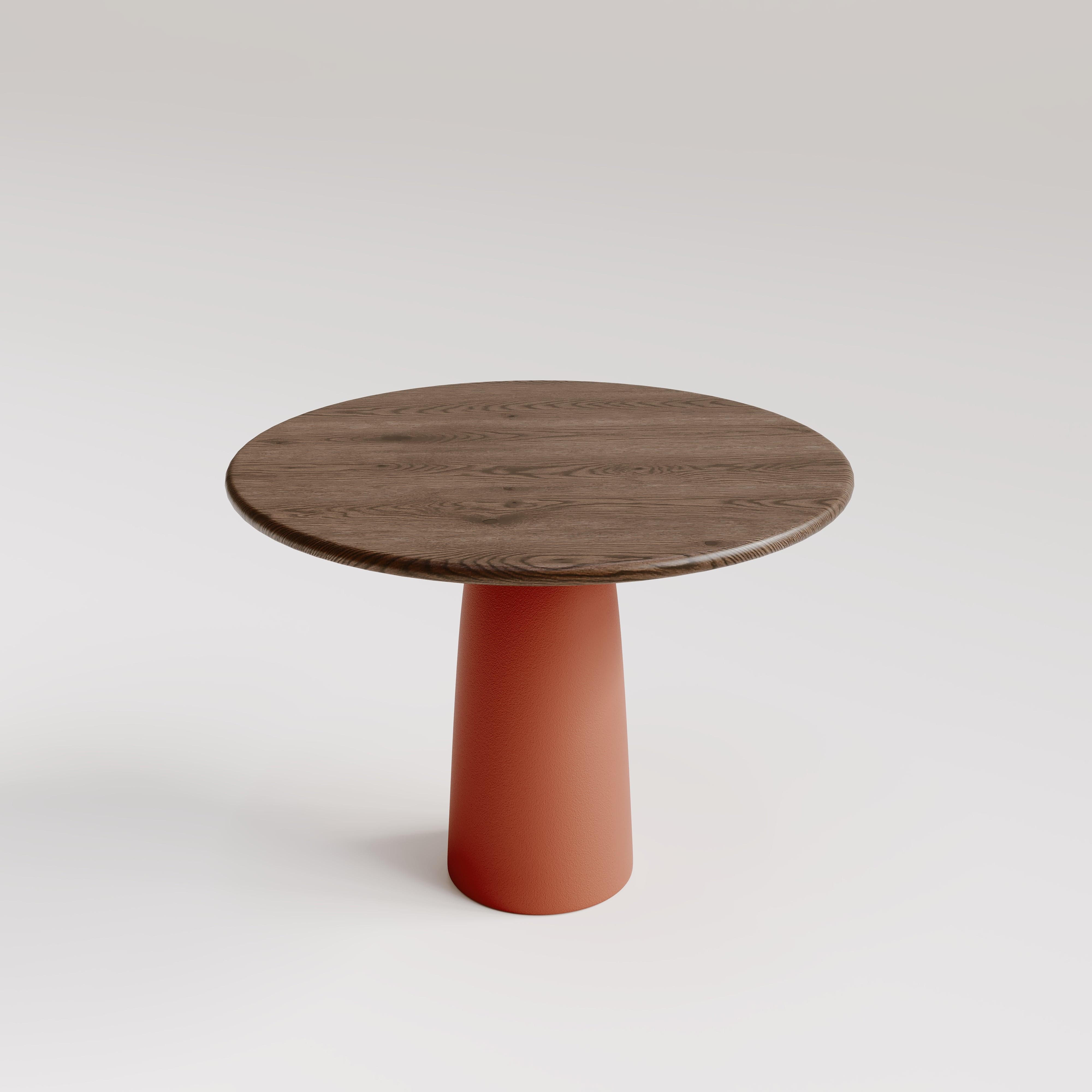 Round solid oak pedestal dining table with terracotta red column base and smoked oak top